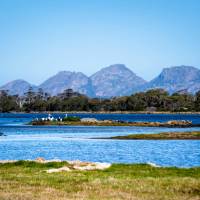 Sheer pink granite mountains overlook the calm, crystal clear water of Oyster Bay | Andrew Wilson